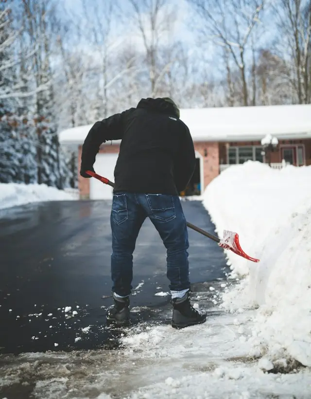 Schnee wird von einer Einfahrt geschippt
